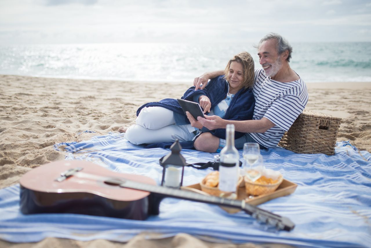 Couple over 50 relaxing together on a beach